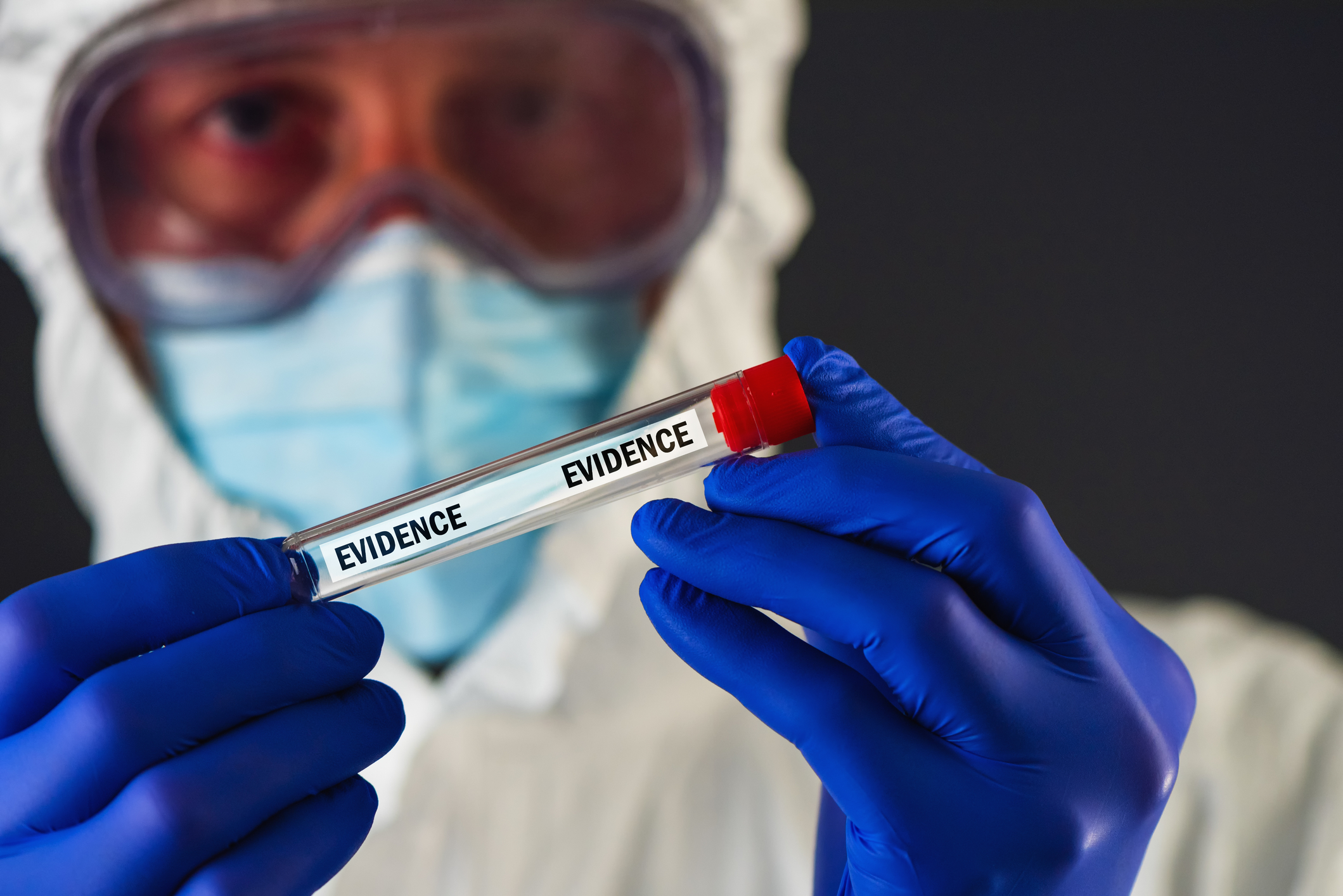 a person in a hazmat suit holding a test tube